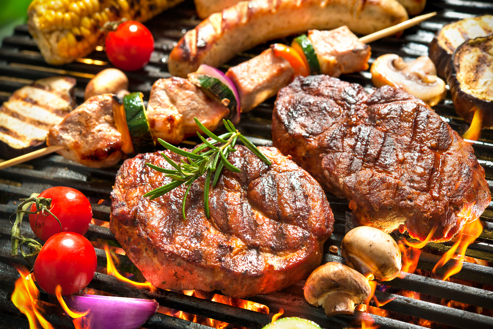 Assorted delicious grilled meat with vegetable over the coals on a barbecue